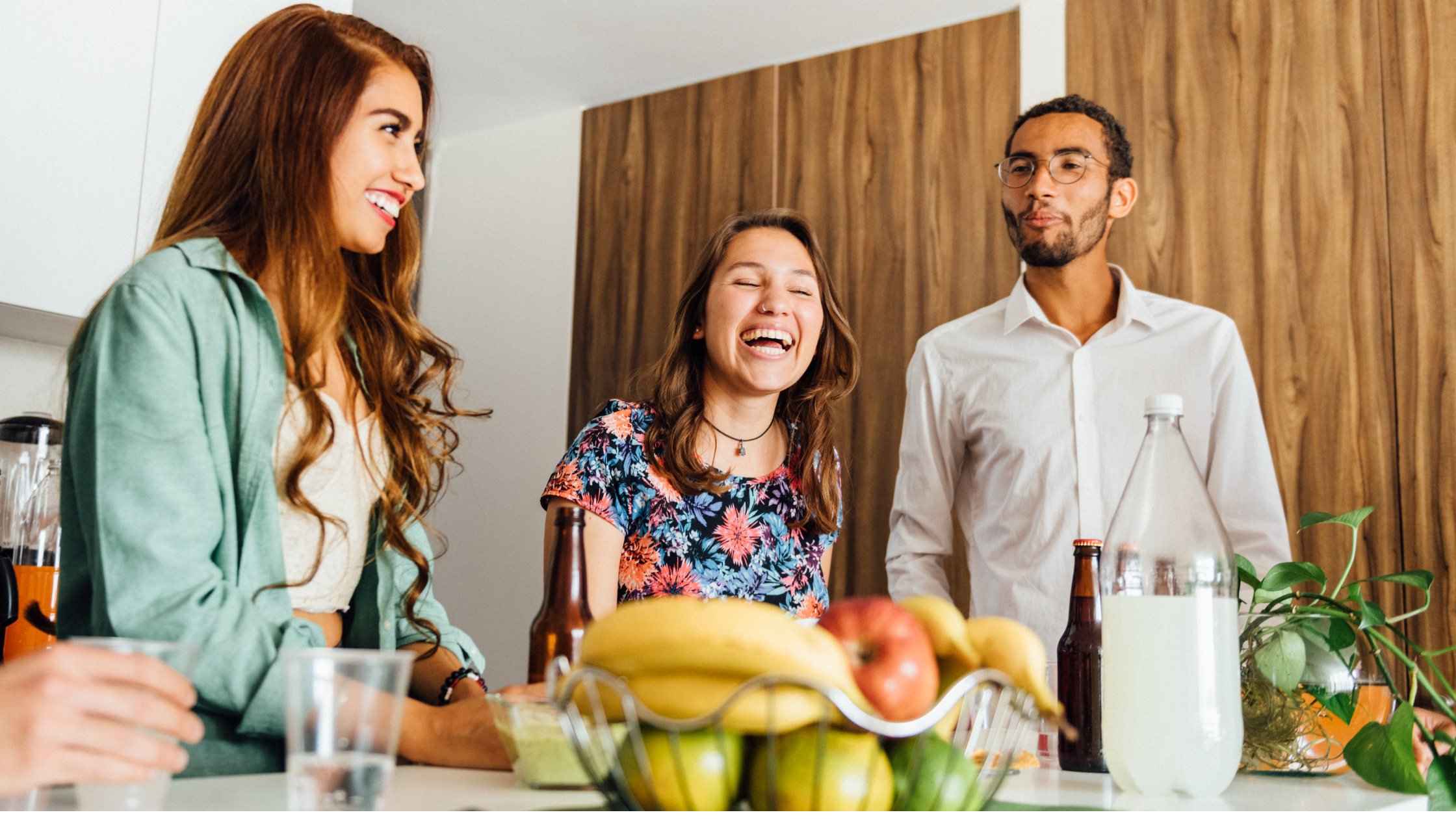 tres amigas riendo en la cocina fiesta de inauguración de una casa