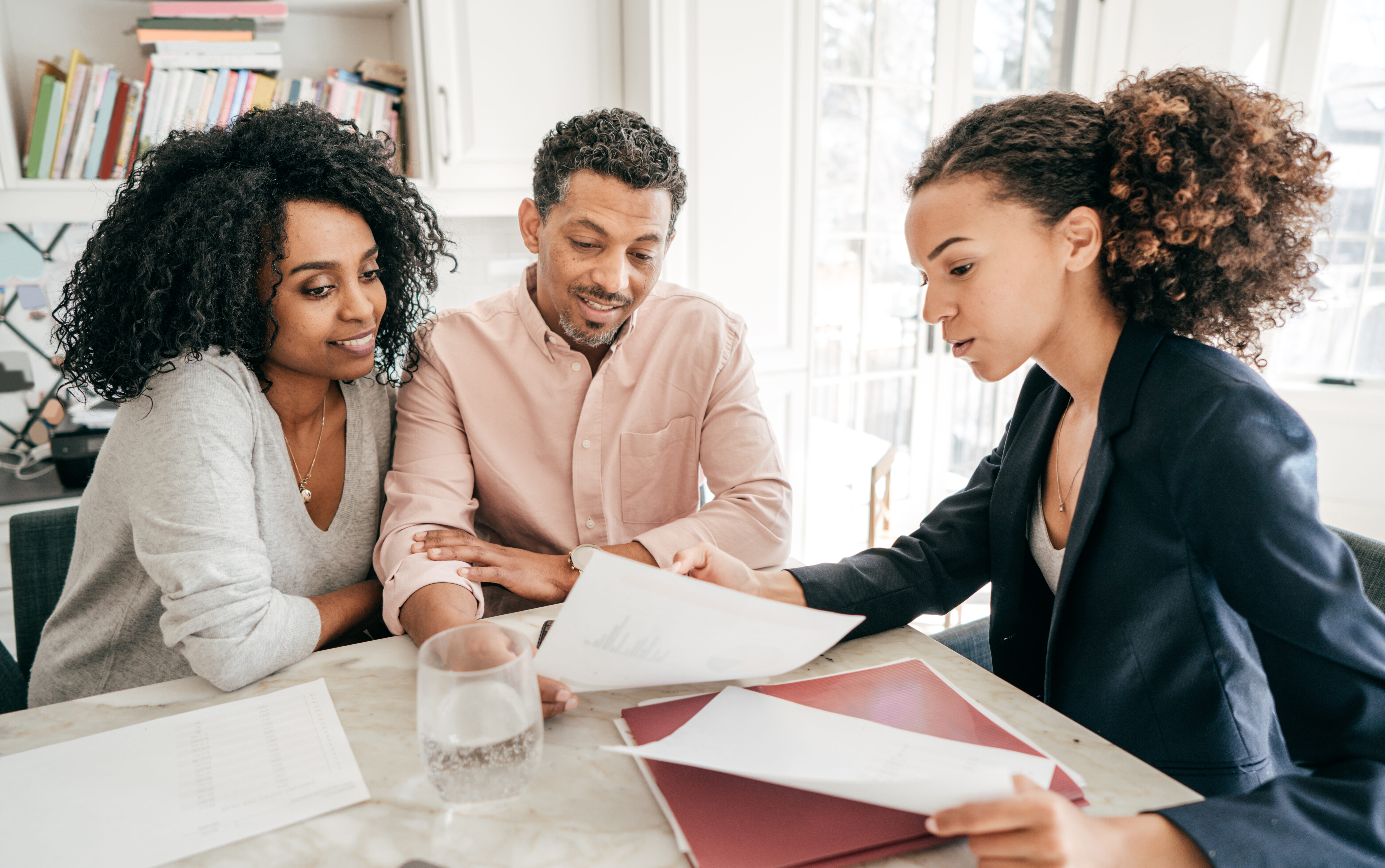 ¿Qué es una guía para comunidades de propietarios con una pareja leyendo documentos sobre la compra de una vivienda?