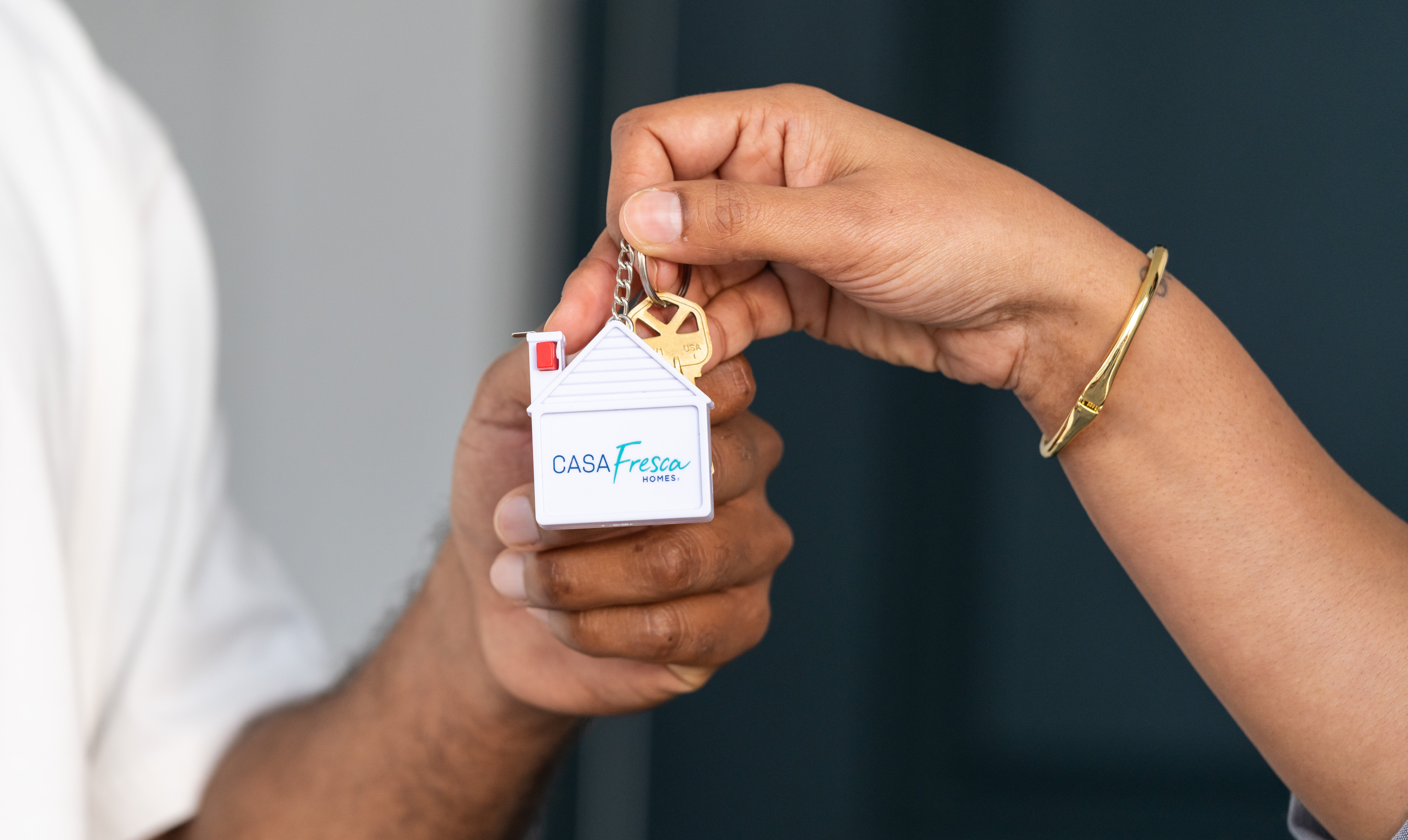 Un comprador de vivienda recibe las llaves de su casa junto con un llavero de Casa Fresca tras elegir entre las opciones hipotecarias para compradores de primera vivienda.